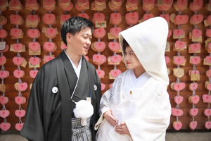 生田神社の絵馬の前で写真を撮る新郎新婦