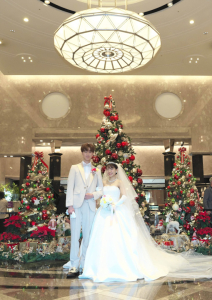 ニューオータニ幕張のクリスマスツリーの前で写真を撮る新郎新婦