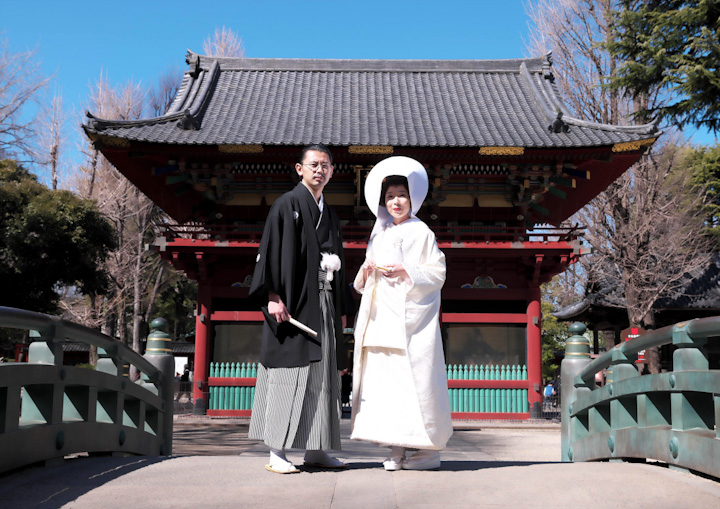 神前式前に根津神社の端上でポーズを取る新郎新婦