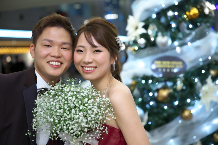 結婚式持ち込みカメラマンが撮影：クリスマスツリーの前でほほ笑む新郎新婦
